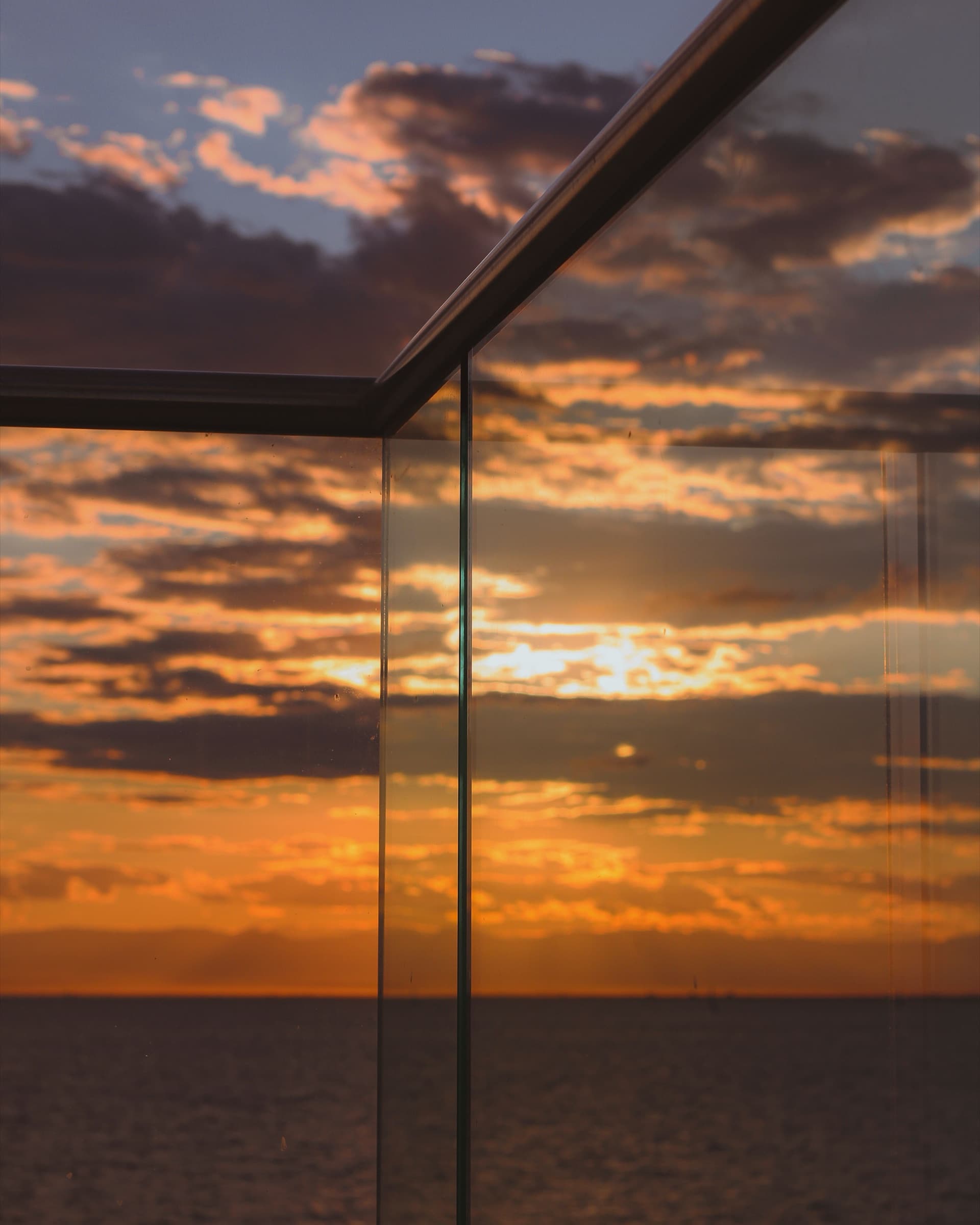 Glasbalkon vor goldenem Abendhimmel